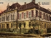Vedere dinspre Sud a clădirii Liceului de Stat, actualmente sediul școlii Sportive din Petroșani, clădire împrejmuită de un gard din lemn